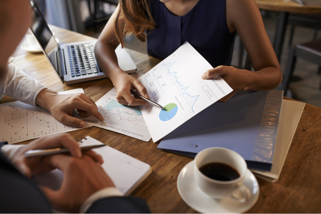 A business woman pointing a pie chart to a coworker.