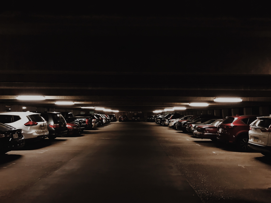 A dark parking lot full of cars.