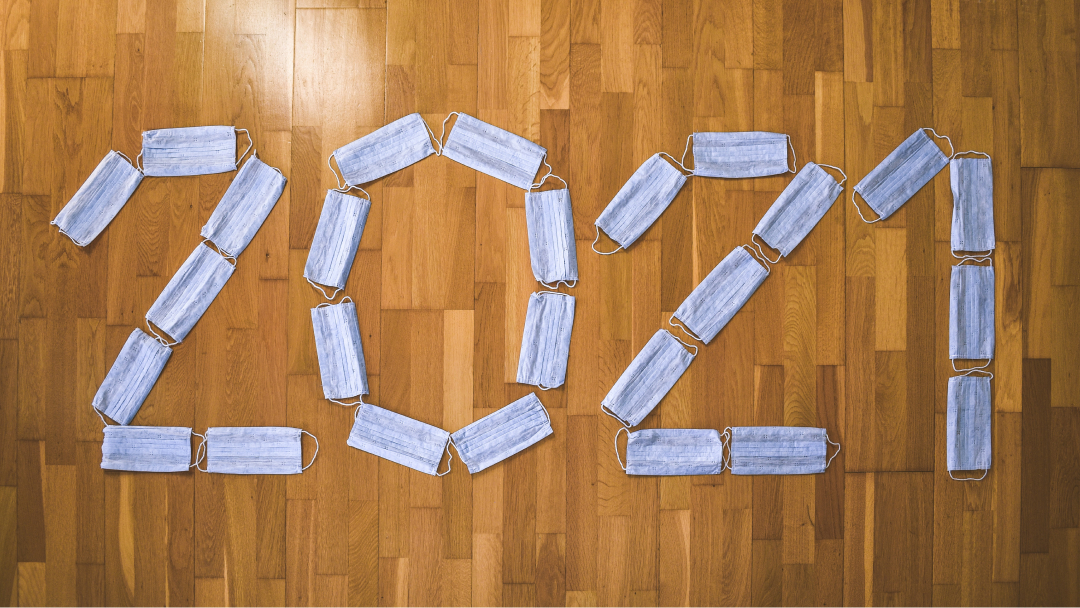 Protective masks arranged on the floor to form the word 2021.